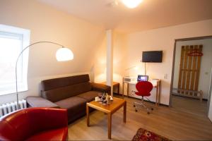 uma sala de estar com um sofá e uma cadeira vermelha em Haus Therese Ferienwohnung *Feodora* (App.11) em Wittdün