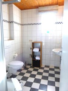 Baño blanco con aseo y lavamanos en Haus Nordlicht Ferienwohnung *Bi Strun*, en Nebel