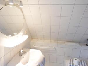 Haus *Üüs Aran* Wohnung Nr. 7 في نيبل: حمام أبيض مع حوض ومرآة
