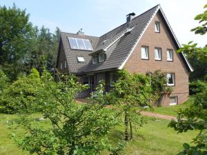 une grande maison en briques avec un toit en gambrel dans l'établissement Haus *Üüs Aran* Wohnung Nr. 3, à Nebel