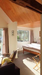 a bedroom with a bed and a large window at Kingfisher B & B in Dunedin