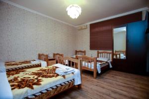 a room with two beds and a table and chairs at Hotel 4You in Tbilisi City