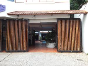 un ingresso a un edificio con due grandi porte in legno di YK Art House a Phnom Penh
