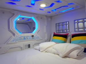 a room with a bed with a mirror and a tv at Galaxy Pods @ Chinatown in Singapore