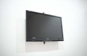 a flat screen tv hanging on a white wall at MG Hotel in Mersing
