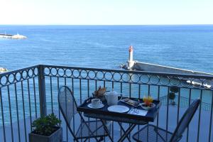 a table with food on a balcony with the ocean at Hôtel Des Gouverneurs in Bastia