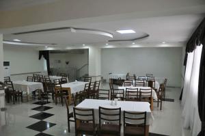 a dining room with white tables and chairs at Hotel Kavkasioni in Kvareli