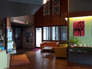 a lobby of a store with a couch and chairs at Hellmut-Waßmer-Jugendherberge Lörrach in Lörrach