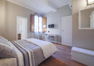 een witte slaapkamer met een bed en een bureau bij Dreamy Brunelleschi in Florence