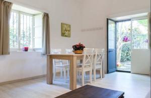 uma sala de jantar com uma mesa e cadeiras brancas em Pietra dell'Etna em Ragalna