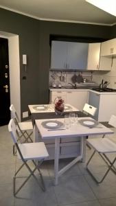 eine Küche mit einem weißen Tisch und Stühlen in einem Zimmer in der Unterkunft Joie de Vivre Torino Statuto in Turin