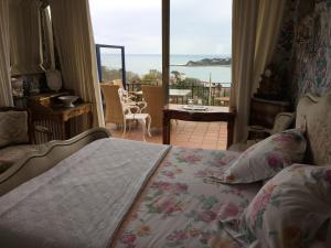 a bedroom with a bed with a view of a balcony at Villa Erresiñolettean in Ciboure