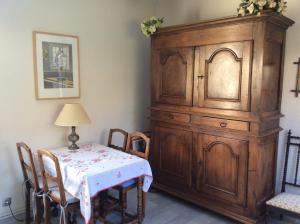 uma sala de jantar com uma mesa e um grande armário de madeira em Studio Montfleury em Corenc