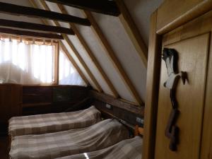 an attic room with two beds and a window at Tradicije Cigoc in Čigoč