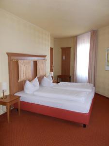 1 dormitorio con 1 cama grande con marco rojo en Berg-Gasthof Honigbrunnen en Löbau
