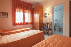 a hotel room with two beds and a bathroom at Hostal Montserrat in Tona