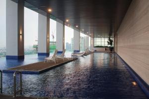 a swimming pool with chairs in a building at Azure Residence Paradigm Mall in Petaling Jaya