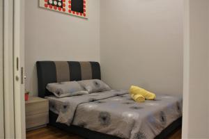 a bedroom with a bed with a yellow pillow on it at Azure Residence Paradigm Mall in Petaling Jaya +16 photos