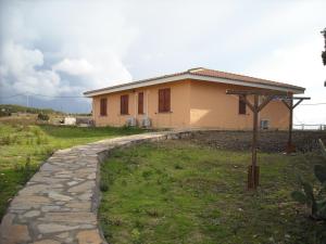 a small house with a stone walkway in front of it at Agriturismo Depalmas in Stintino