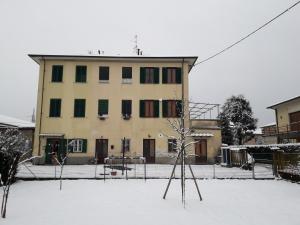 a building in the snow with a tree in front of it at Affittacamere Rossi in Lucca