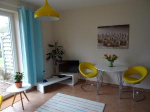 ボルンにあるBoddenpieperのリビングルーム(黄色い椅子、テーブル、テレビ付)