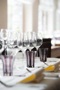 un groupe de verres à vin assis sur une table dans l'établissement Hotel Le Moulin Simonis, à Laforêt