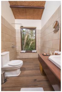 La salle de bains est pourvue de toilettes, d'un lavabo et d'une fenêtre. dans l'établissement Fateh's Retreat, Homestay, à Sawai Madhopur