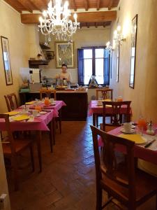 a man in a kitchen with a table in a restaurant at B&B Palazzo Al Torrione in San Gimignano
