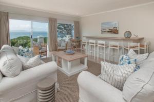 a living room with white furniture and a view of the ocean at On The Rocks in Hermanus