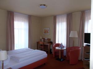 a hotel room with a bed and a table and chairs at Berg-Gasthof Honigbrunnen in Löbau