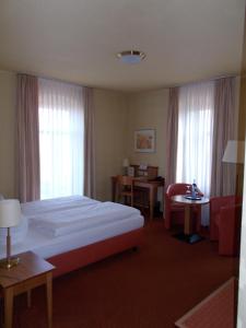 a hotel room with a bed and a chair at Berg-Gasthof Honigbrunnen in Löbau