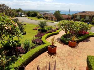 einen Garten mit einem Ziegelweg mit Pflanzen und Sträuchern in der Unterkunft Jervis Bay Blue - Vincentia in Vincentia