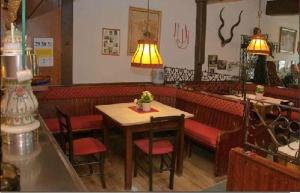 restauracja ze stołem, krzesłami i lampką w obiekcie Hotel Ratskeller Gehrden w mieście Gehrden