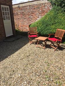 two chairs and a table next to a brick wall at Studio at The Old Vicarage in Abingdon