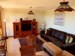 a living room with a couch and a tv at Jervis Bay Blue - Vincentia in Vincentia