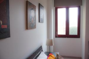 a room with a bed and a window and pictures at Alameda Guest House RC in Espinho +10 photos