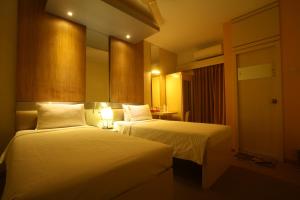 a hotel room with two beds and a mirror at Hotel Ornate in Dhaka