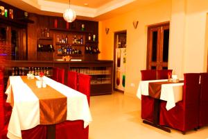 a restaurant with two tables with red chairs and a bar at Hotel Dream City in Kathmandu