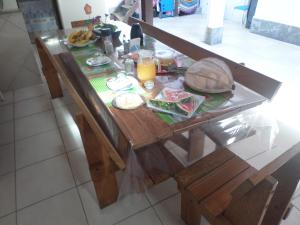 a wooden table with food and drinks on it at Cantinho do Canaã in Arraial do Cabo