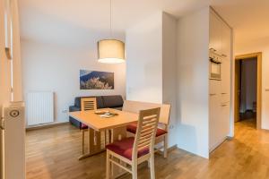 uma sala de jantar e sala de estar com mesa e cadeiras em Haus Gufler em Silandro