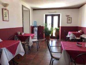 a restaurant with red and white tables and chairs at Agriturismo Antica Sosta in Viterbo