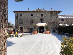 a large stone building with snow in front of it at Agriturismo Antica Sosta in Viterbo