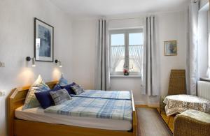 a bedroom with a bed and a chair and a window at Pension "Haus am Walde" Brodenbach, Mosel in Brodenbach