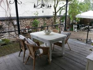 een witte tafel en stoelen op een houten terras bij Das Rosenhaus in Lieser