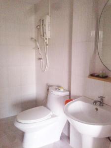 a white bathroom with a toilet and a sink at is boutique huahin hotel in Hua Hin