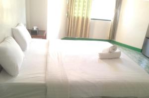 a white bed with a towel on top of it at is boutique huahin hotel in Hua Hin