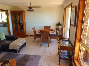 ein Wohnzimmer mit einem Tisch und einem Sofa in der Unterkunft Jervis Bay Blue - Vincentia in Vincentia
