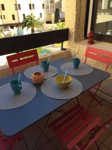 uma mesa azul com tigelas e utensílios em Résidence les dromadaires em Gruissan