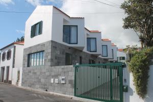 une maison avec une porte verte dans une rue dans l'établissement H18, à Horta