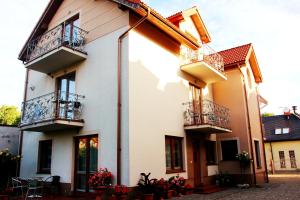 a white building with balconies and tables and flowers at Willa Feniks in Łeba